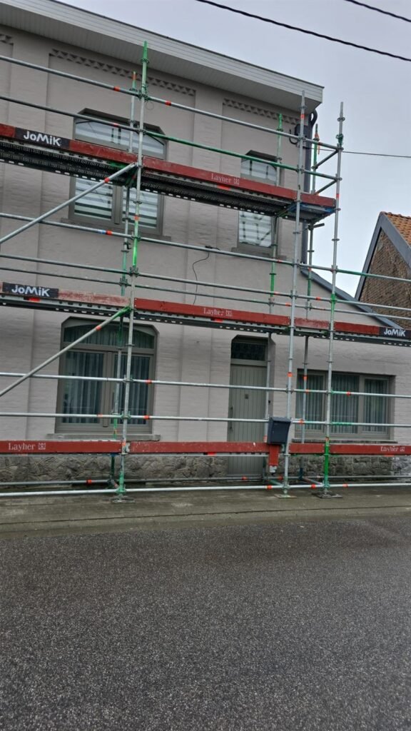 Maison de village peinte en taupe, échafaudage en place